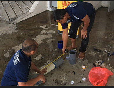 Plumbers working on floor pipes