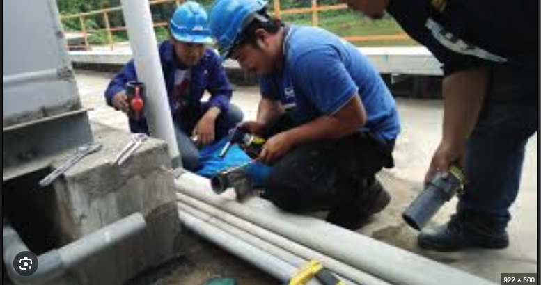 Plumbers working outdoors